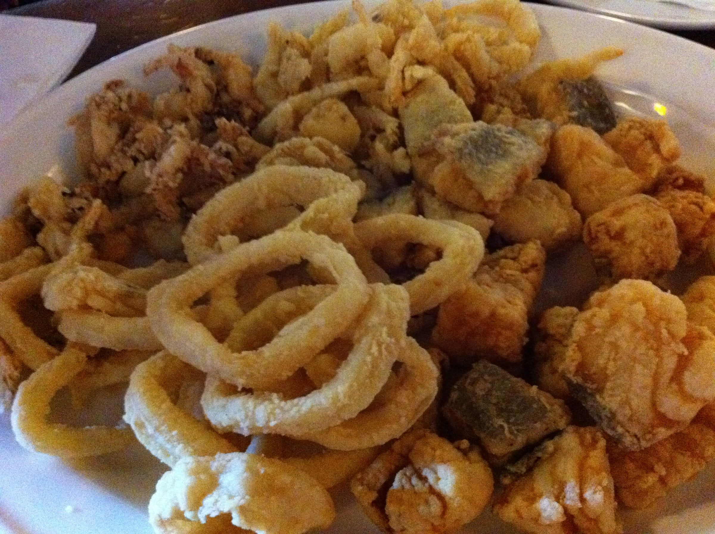 Plato de pescaíto frito en un bar de Málaga, con anillas de calamar, chopitos y tacos de pescado rebozados en harina
