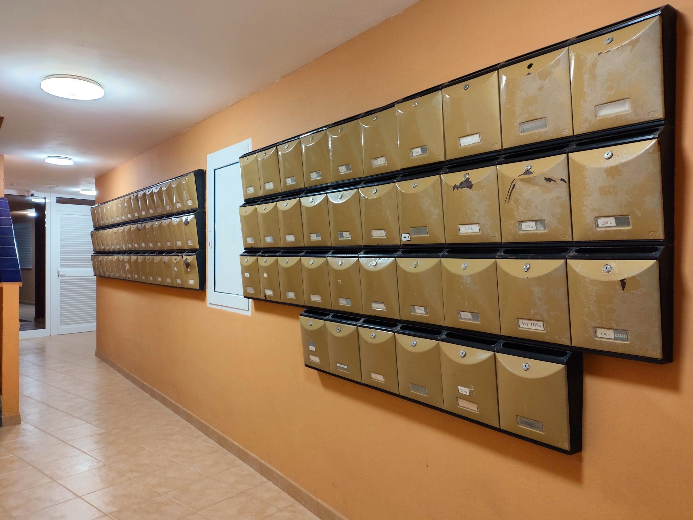 Buzones metálicos en el portal de un edificio de viviendas en España, en la zona común junto al pasillo de entrada